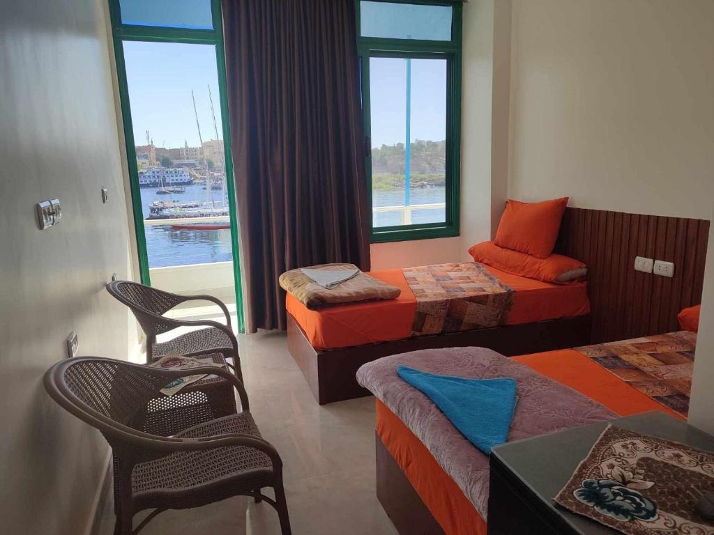 a hotel room with two beds and a window at New El Amin Guesthouse in Aswan