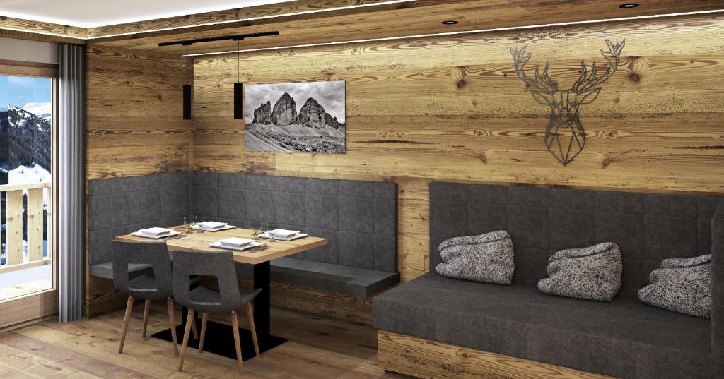een eetkamer met een tafel en een tafel en stoelen bij Apartment Waldheim - Alpine Elegance in Sesto