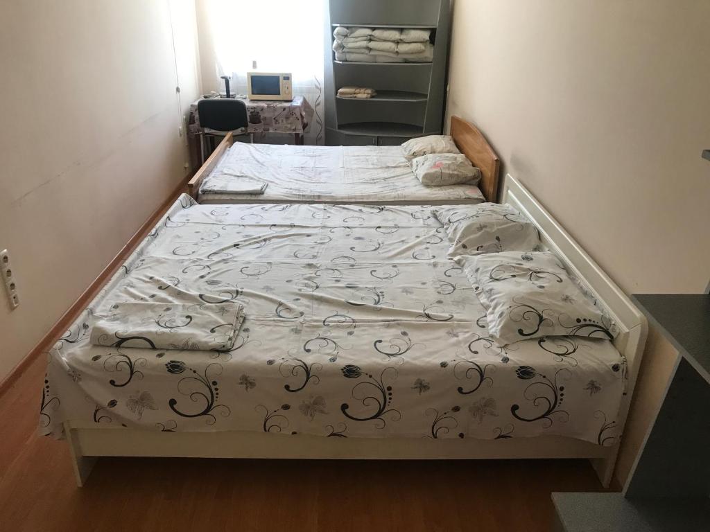 Una cama en una habitación pequeña con colcha. en Окремий номер, en Chernivtsi