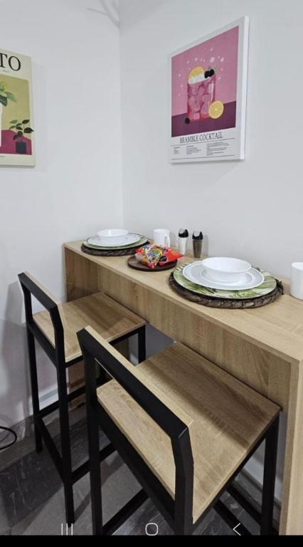 a table with two chairs and two plates on it at Edificio Ivonne in Cali