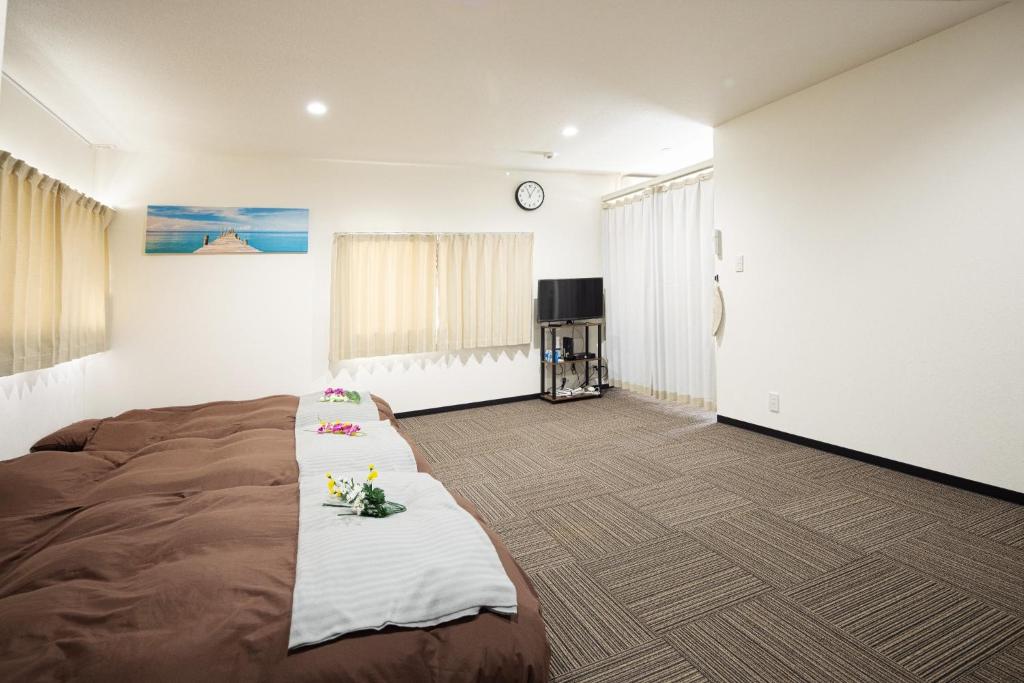 ein Schlafzimmer mit einem großen Bett und einer Uhr an der Wand in der Unterkunft Guest House Shine Bright - Vacation STAY 19290 in Fukuoka