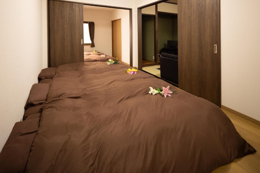 a bed in a room with flowers on it at Guest House Shine Bright - Vacation STAY 19289 in Fukuoka