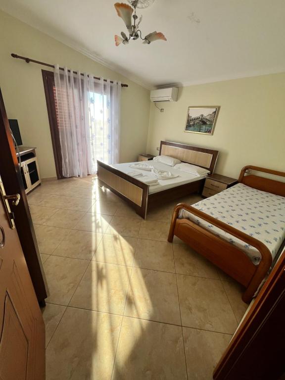 una camera da letto con due letti e una finestra di Guesthouse Fatos Biti a Divjakë