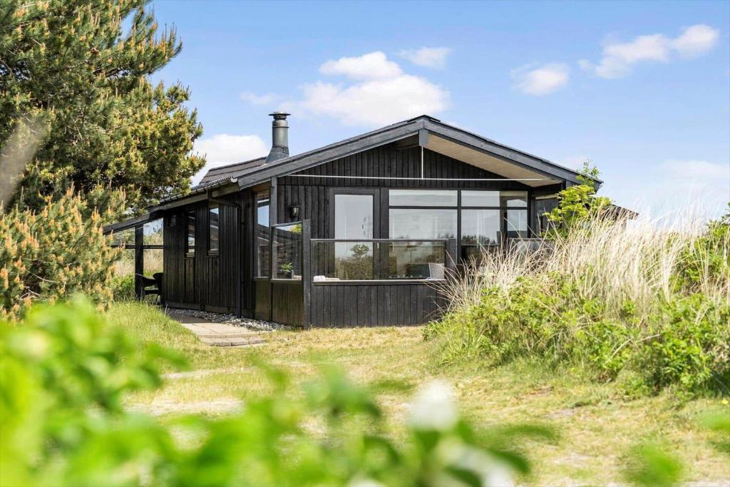 een zwart huis bovenop een veld bij 235-Ringkobing-Vestklitvej-11 in Klegod