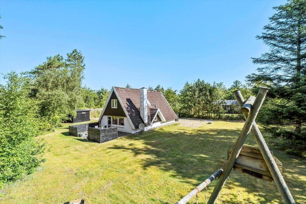 una casa con un cortile con una casa di legno di 1106-ringkobing-Klitrosevej-4 a Nørby
