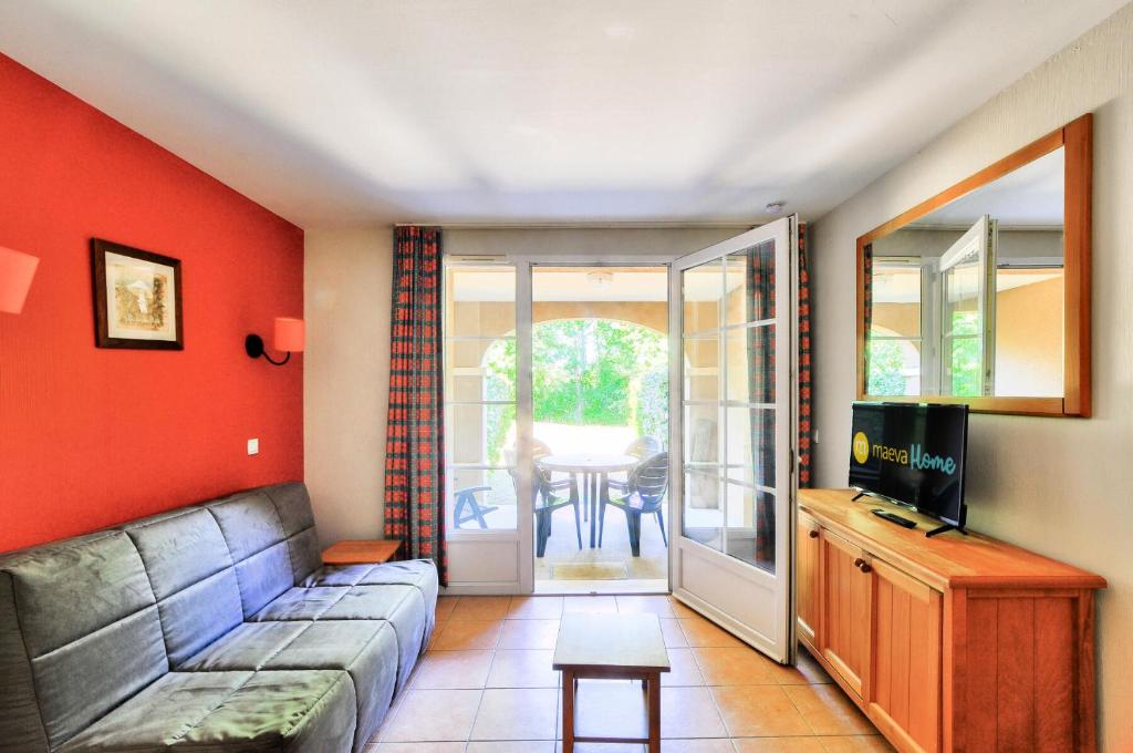 ein Wohnzimmer mit Sofa und Fernseher in der Unterkunft La résidence du Lac - maeva Home - Appartement 2 pièces 4 personnes - Sélection MAE-0263 in Monflanquin