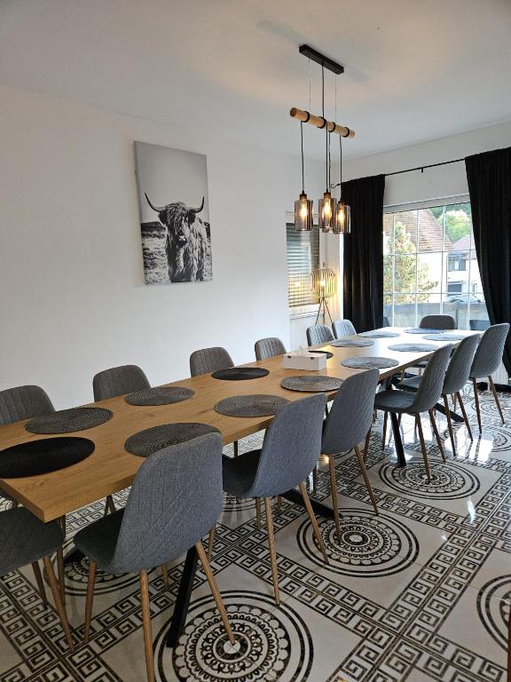 a dining room with a wooden table and chairs at Gästehaus Schindhard in Schindhard