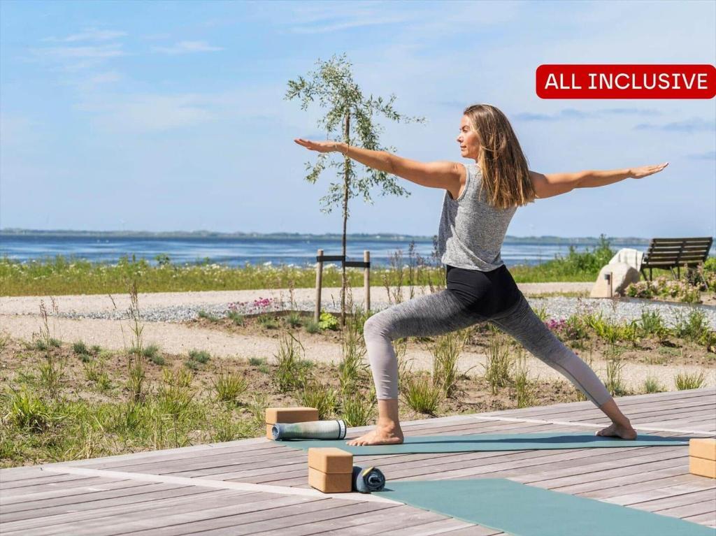 a woman doing yoga on a yoga mat near the beach at 1172-Ringkobing-Jagtvej-34-C-lejl-3 in Ringkøbing