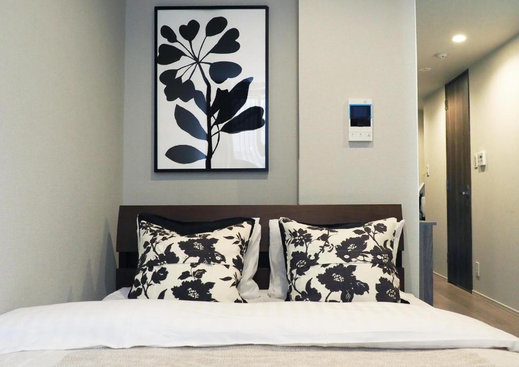 une chambre avec un lit avec des oreillers noirs et blancs dans l'établissement LANG HOTEL Kameido - Vacation STAY 71097v, à Tokyo