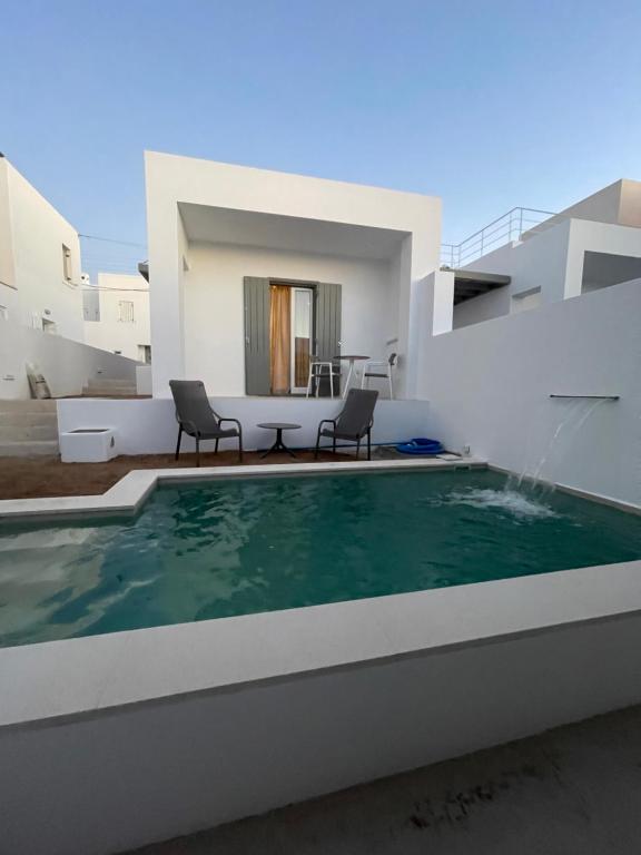 una villa con piscina e una casa di Kyma & Anemos Suites a Naoussa