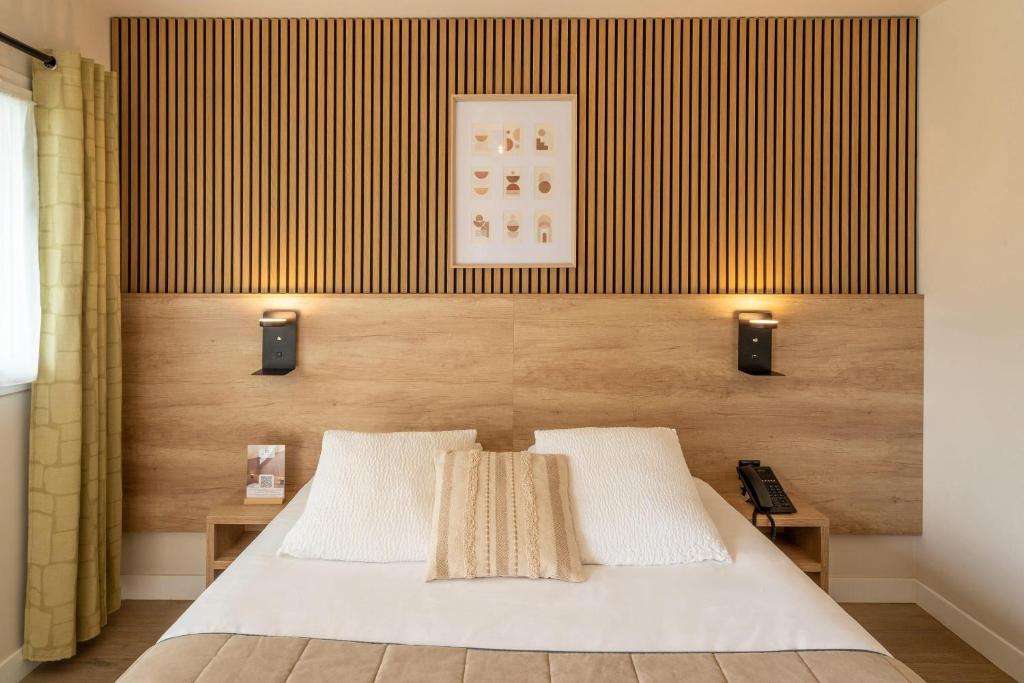 a bedroom with a bed with two lights on it at Sure Hotel by Best Western Mont-de-Marsan in Saint-Pierre-du-Mont