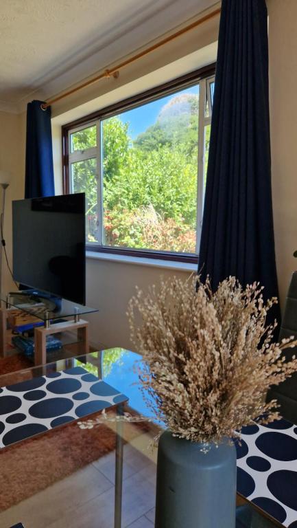 a living room with a large window and a tv at 1-Bedroom Annexe in Brighton-Saltdean in Saltdean