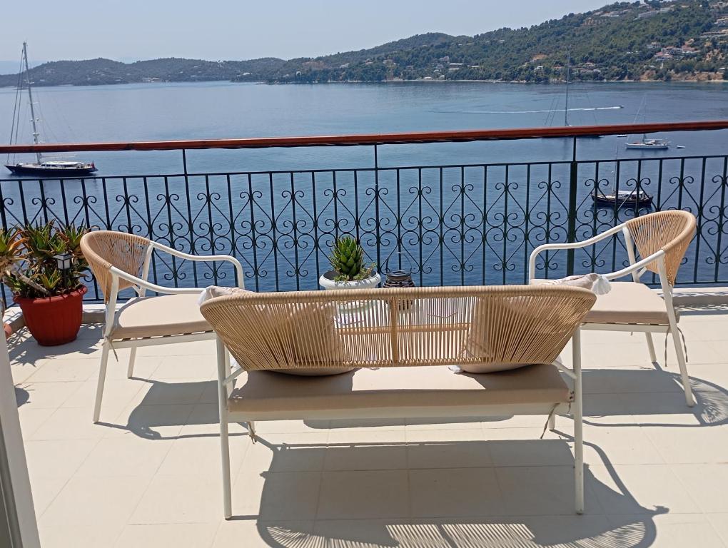 a table and chairs on a balcony overlooking the water at Thea Rooftop in Skiathos