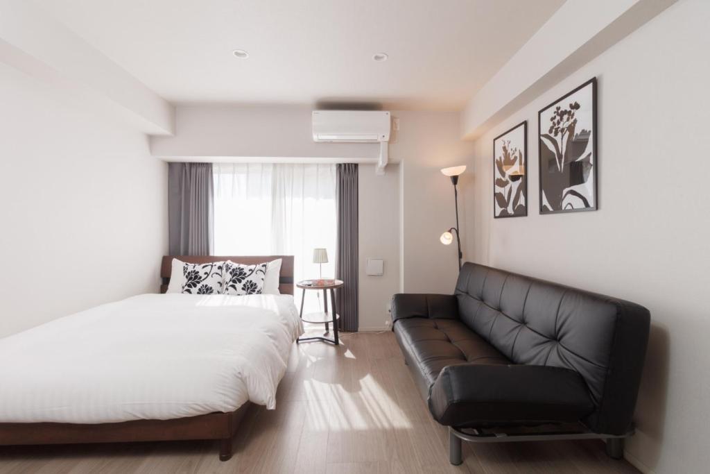 a bedroom with a bed and a couch at LANG HOTEL Kameido - Vacation STAY 76954v in Tokyo