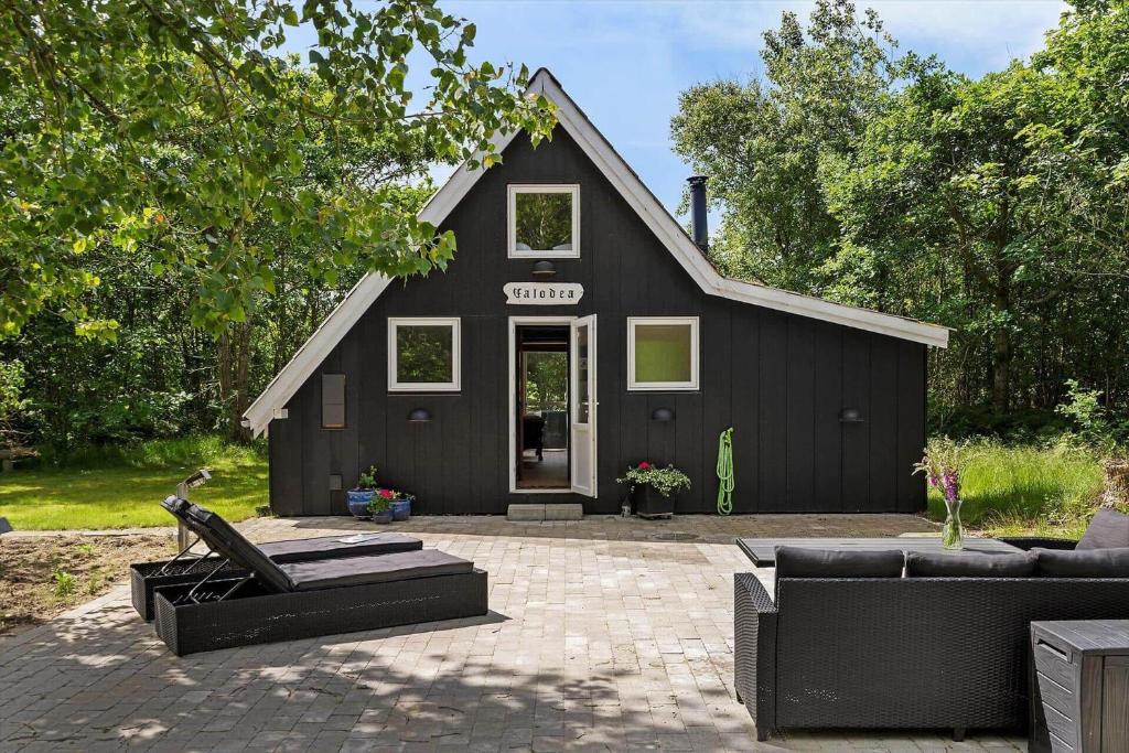 a black house with couches in front of it at 1105-ringkobing-Fyrrealle-20 in Nørby