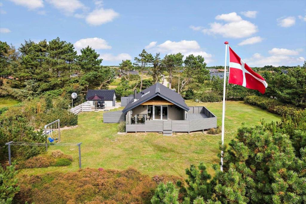 a house with a flag on top of a yard at 1103-Ringkobing-Frans-Julius-Vej-17 in Klegod