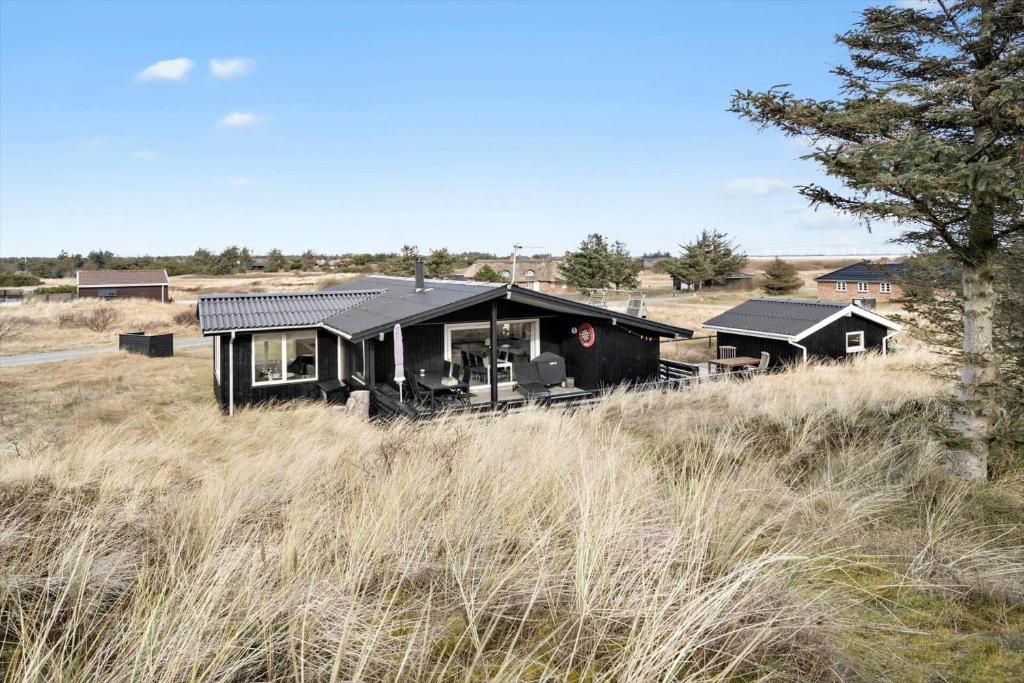 a black house in the middle of a field at 278-Ringkobing-Fladsbjergvej-54 in Klegod