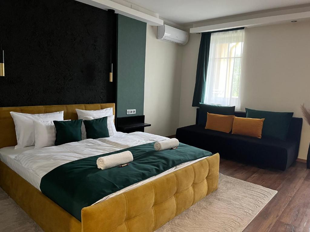 a bedroom with a large bed and a couch at Casa Lara Apartman in Egerszalók