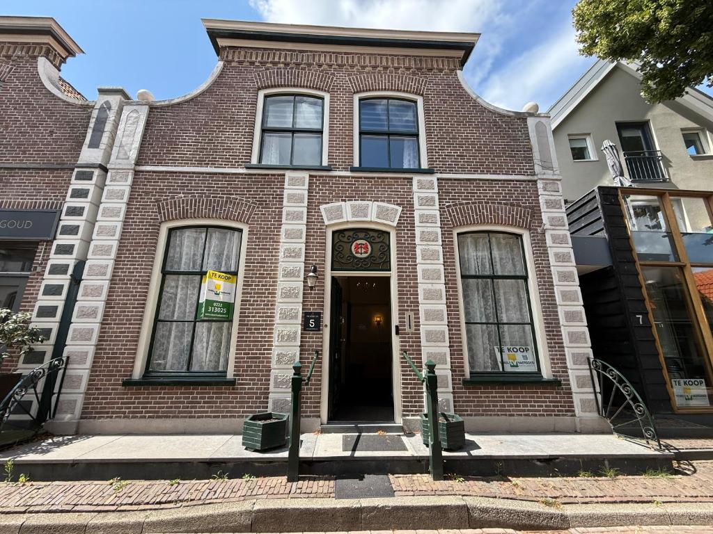 a brick building with a door on a street at Theislandlife 10p Centrum Texel in Den Burg