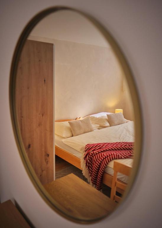 a mirror reflection of a bed in a bedroom at vila Barbara - Vysoké Tatry in Stará Lesná