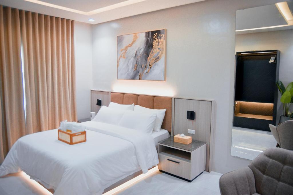 a hotel room with a bed and a chair at Kabin Tiny Home in Roxas City