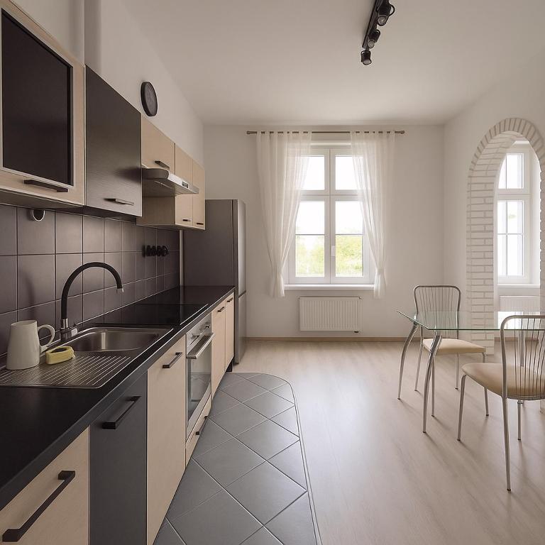 a kitchen with a sink and a table with chairs at Silver Stone by Grafit in Legnica