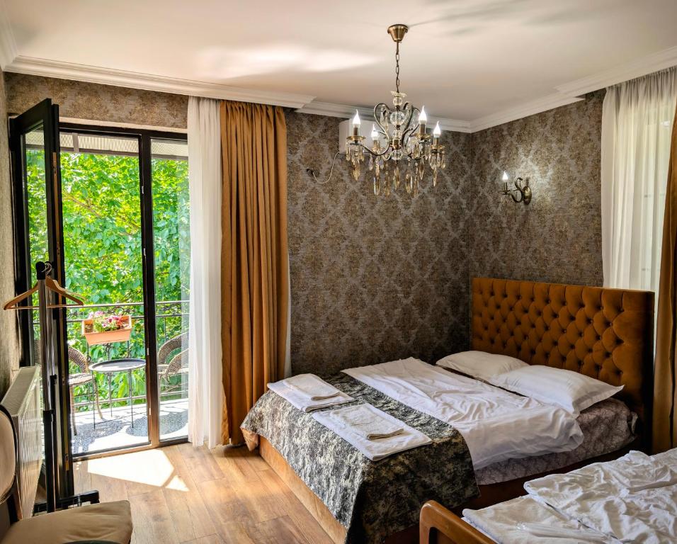 a bedroom with two beds and a chandelier at Sunny Days Borjomi in Borjomi