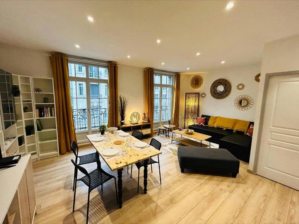 un salon avec une table, des chaises et un canapé dans l'établissement L’etape des sacres, à Reims