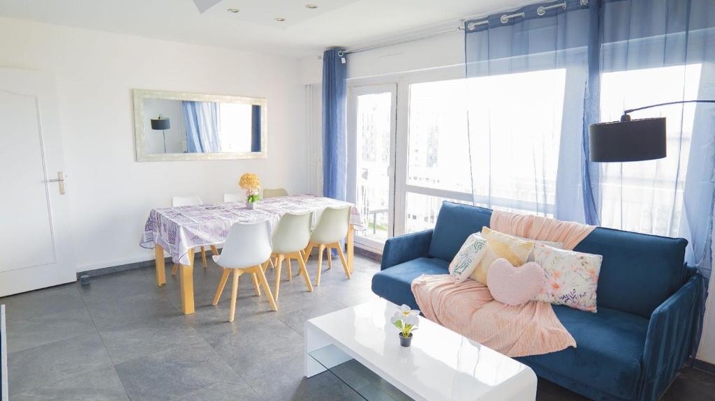 a living room with a blue couch and a table at T5 Spacieux Métro Parking 2 min Créteil Soleil in Créteil