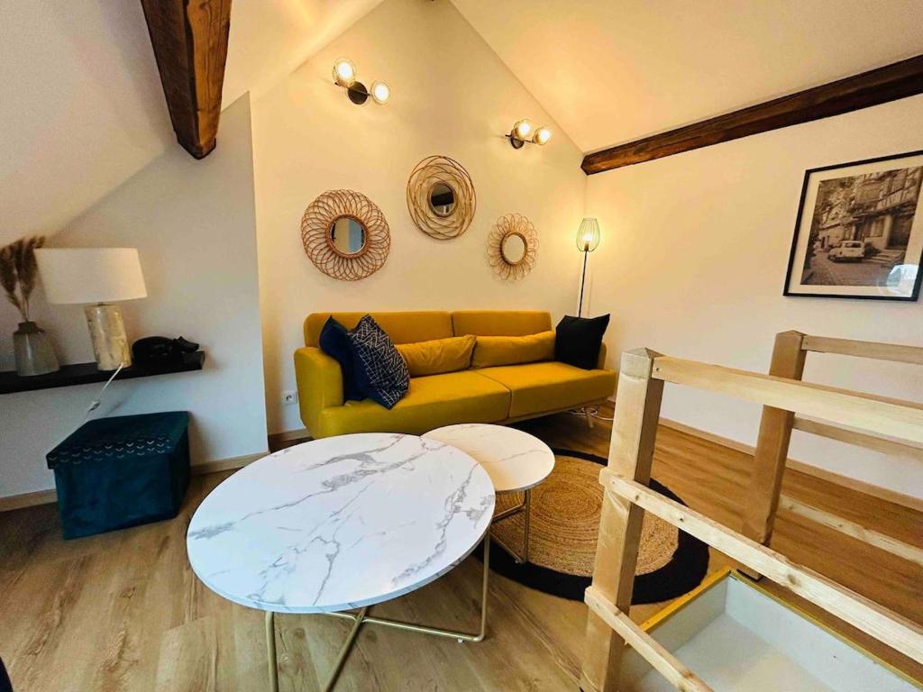 un salon avec un canapé jaune et une table dans l'établissement Les Toits de Thillois Hypercentre, à Reims