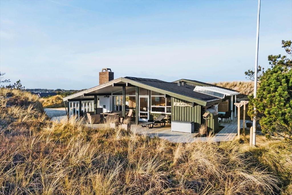 a house with a deck in the middle of a field at 1149-Ringkobing-Holmsborgvej-32 in Søndervig