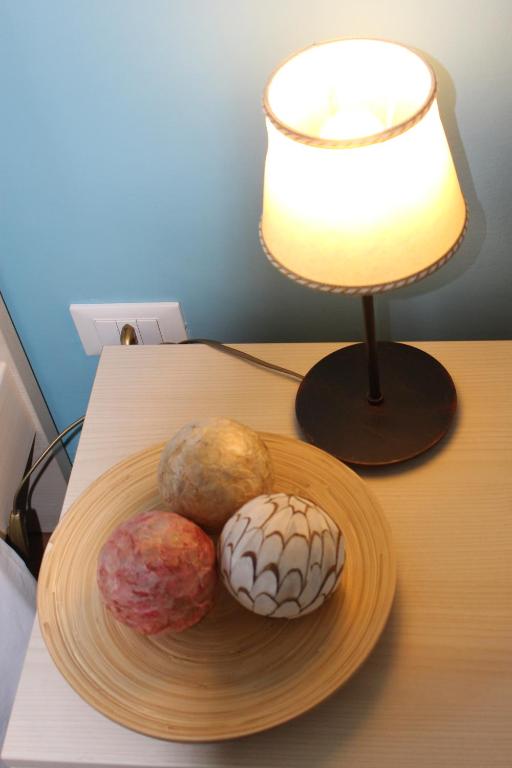 a plate of donuts on a table next to a lamp at B&B I' Chivi in Incisa in Valdarno