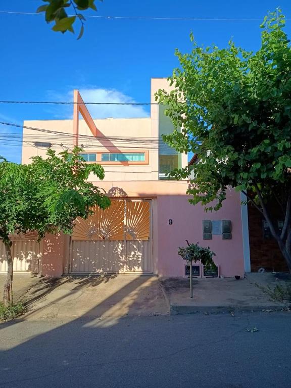 a pink building with a tree in front of it at Espaço Dona Deja in Bom Jesus da Lapa