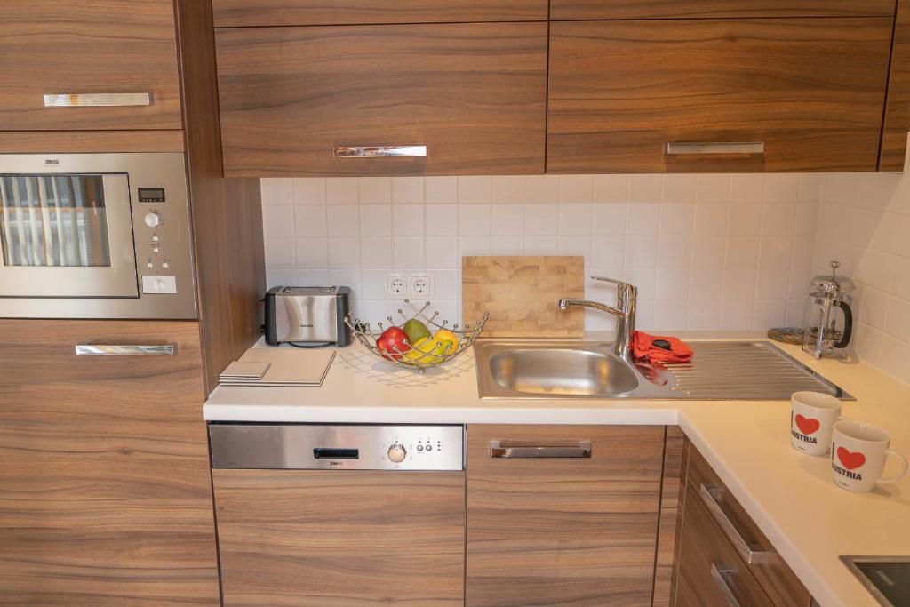 ラウリスにあるMartina 6 by SMR Rauris Apartments - inc Spa and near Gondolaのシンクとカウンタートップのあるキッチン