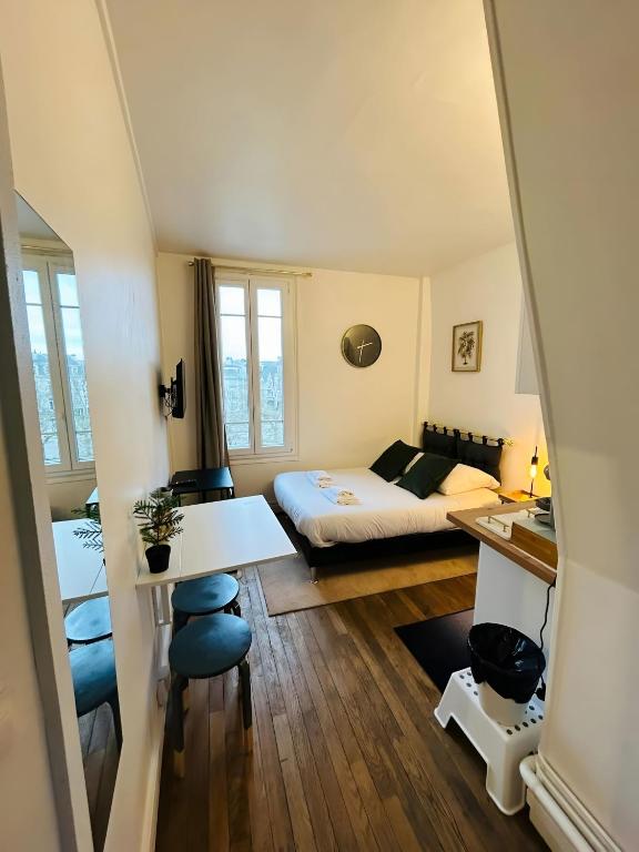 une petite chambre avec un lit et un bureau dans l'établissement La Suite Briand - Hypercentre, à Reims