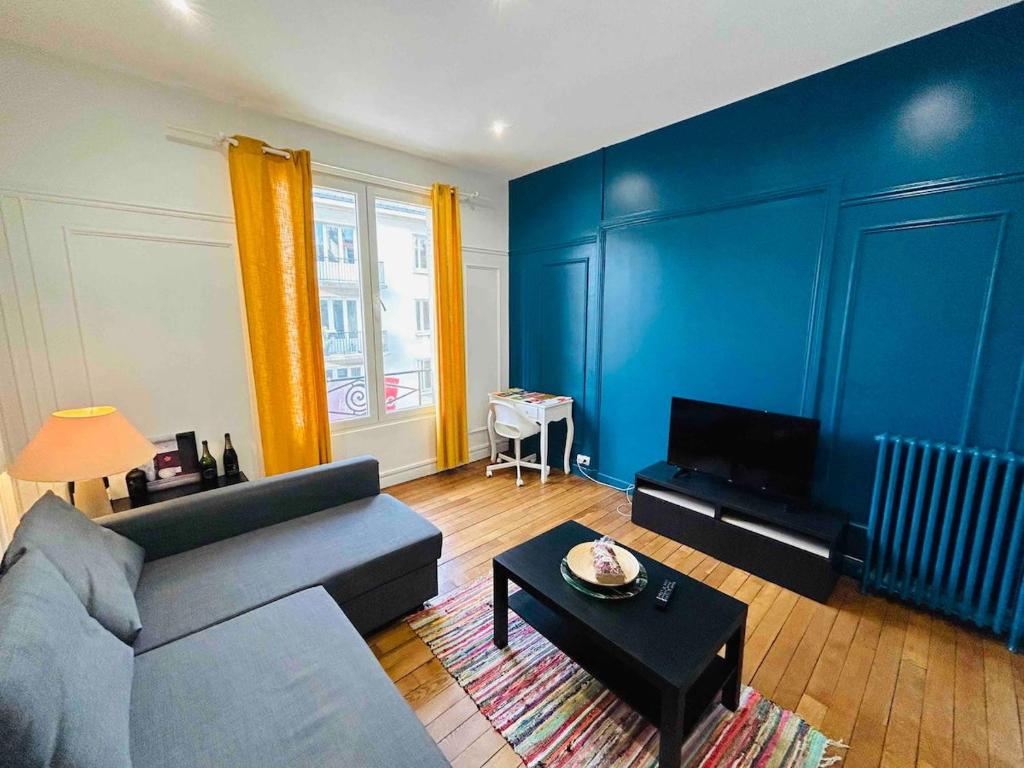 - un salon avec des murs bleus, un canapé et une table dans l'établissement L'Etape Rémoise - Hypercentre, à Reims