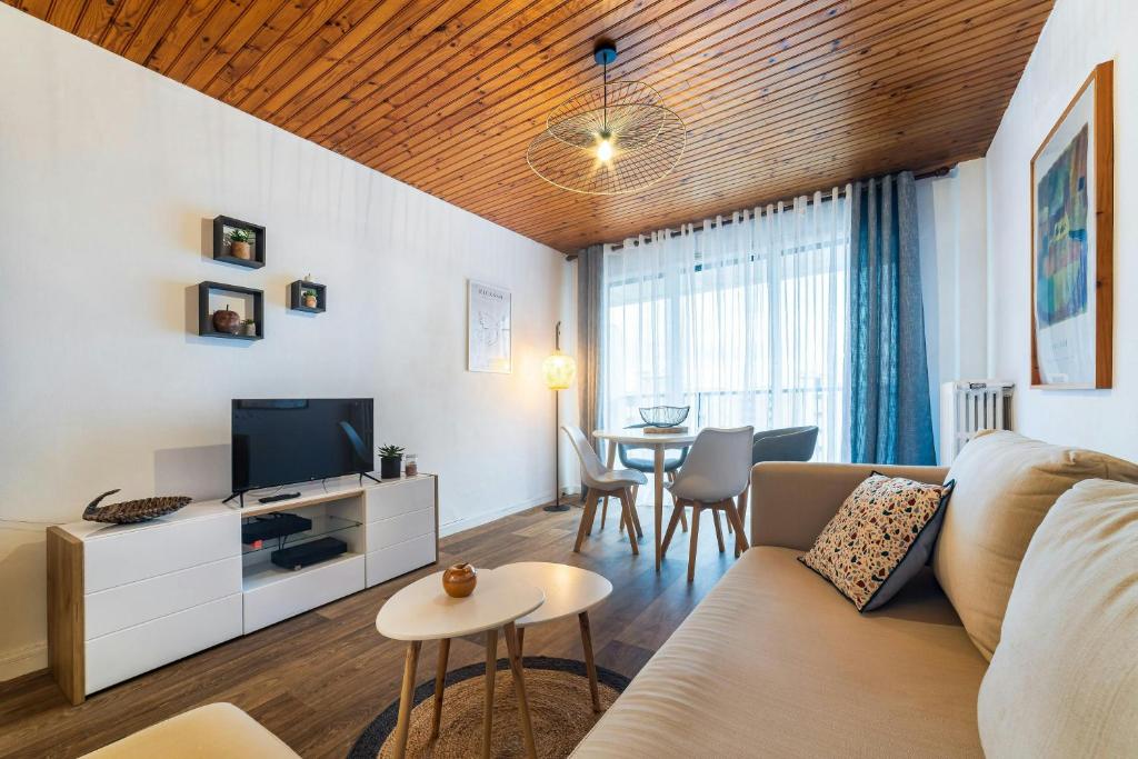 a living room with a couch and a tv and a table at Studio Ensoleillé à Saint-Maur - Proche Paris in Saint-Maur-des-Fossés