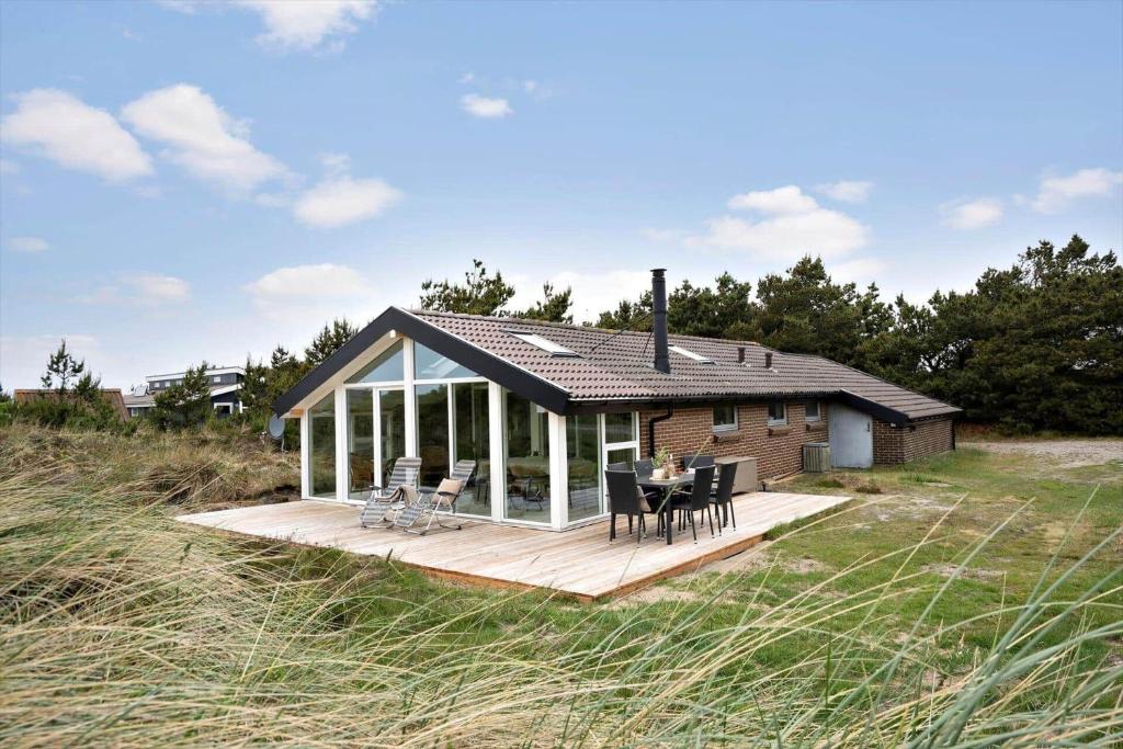 a house on a deck with a table and chairs at 2253-Ringkobing-Fladsbjergvej-234-E in Klegod