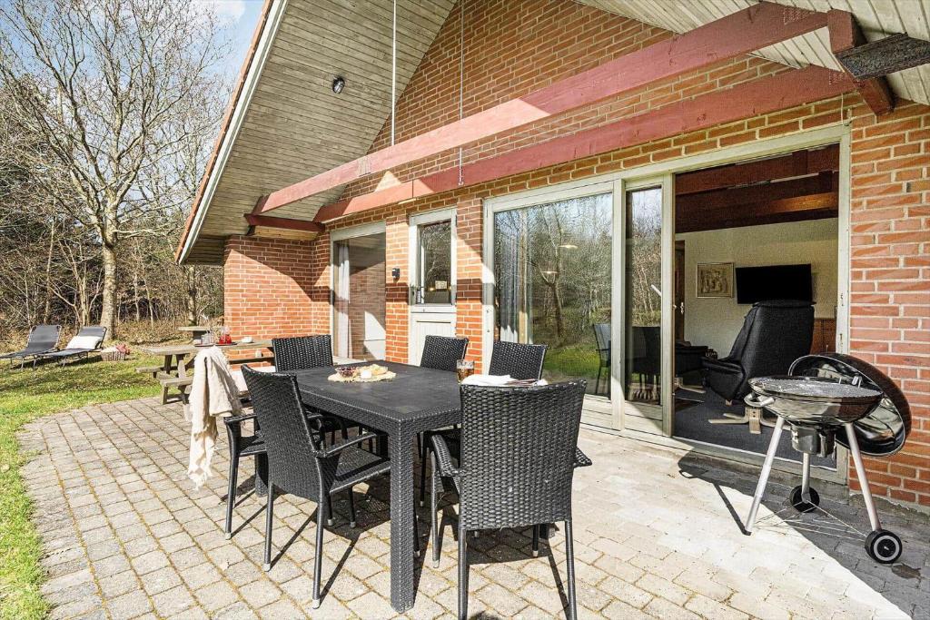 113-Ringkobing-Ahornalle-16 في Nørby: فناء مع طاولة وكراسي وشواية