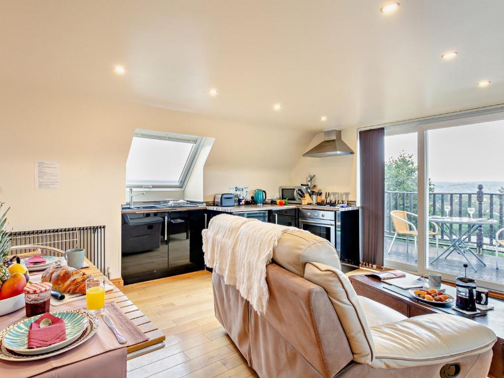 Una sala de estar con un sofá y una cocina. en 1 bed in Barnstaple ELLCO, en Fremington