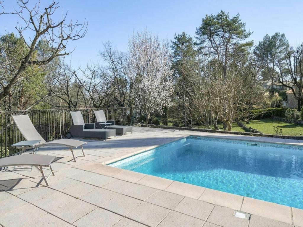 - une piscine avec 2 chaises à côté d'une clôture dans l'établissement CASA-Catherine jolie villa piscine et grand jardin, à Callian