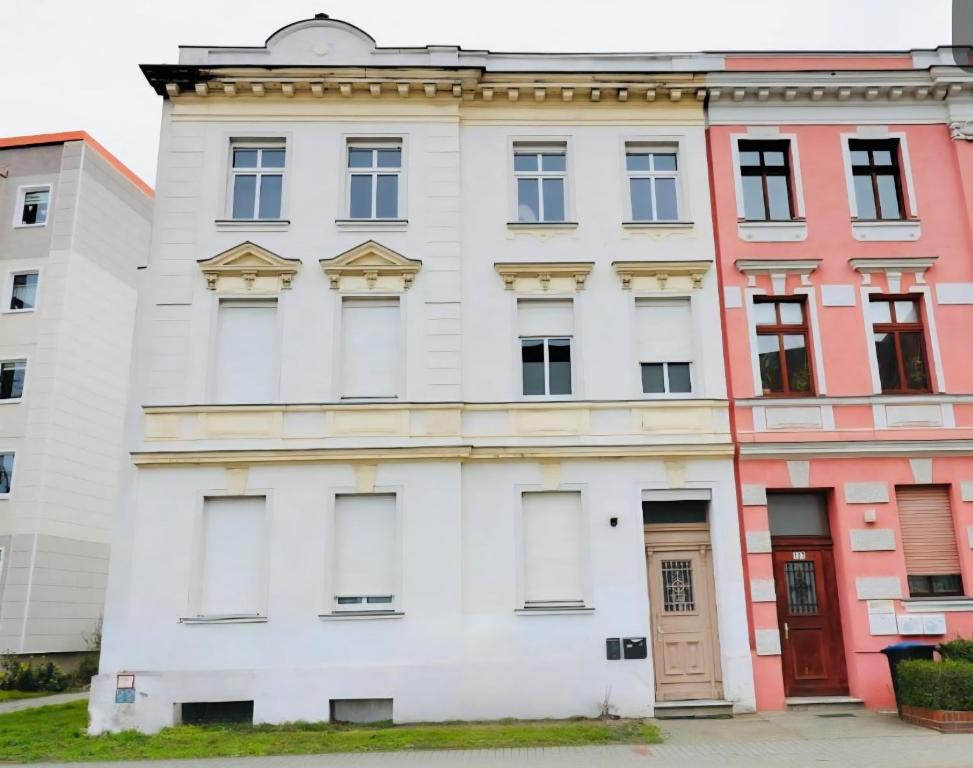 an old white building with a red door at City Apartment I 75qm I Kostenloser Parkplatz I Nähe Staatstheater I WLAN in Cottbus