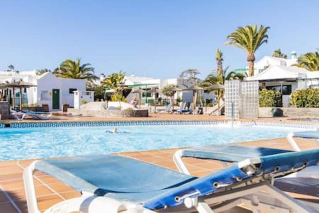 a swimming pool with a blue at Casa Roma in Puerto del Carmen