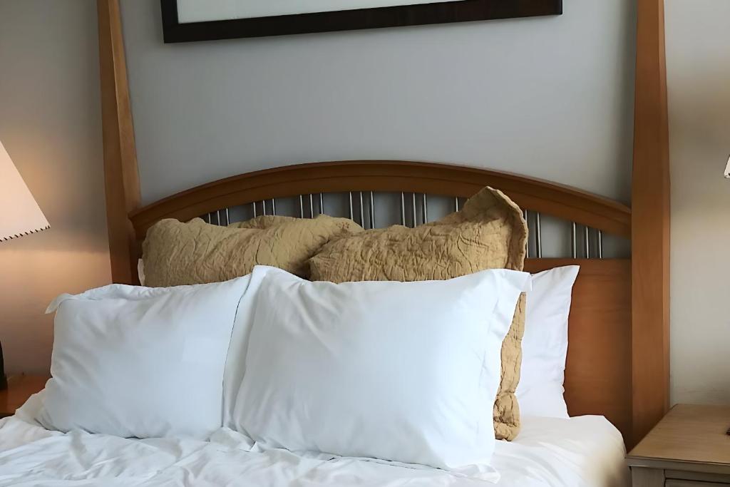 a bed with white pillows and a wooden headboard at VILLA Verde Surprise Stadium - Resort Living in Surprise