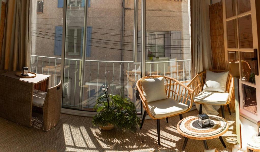 d'un balcon avec deux chaises et une fenêtre. dans l'établissement LeCosy - Studio 2 Personnes, à Gréoux-les-Bains