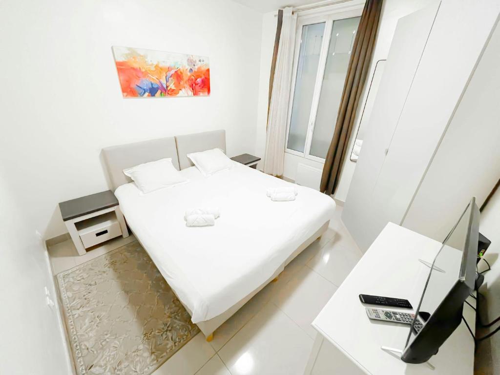 a white bedroom with a bed and a desk at 5 minutes de Paris T2 cocon village dIvry in Ivry-sur-Seine