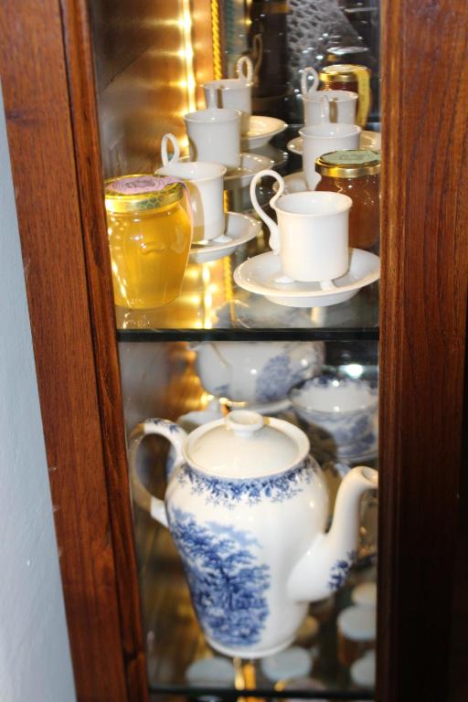 a glass cabinet filled with tea cups and saucers at B&B I' Chivi in Incisa in Valdarno