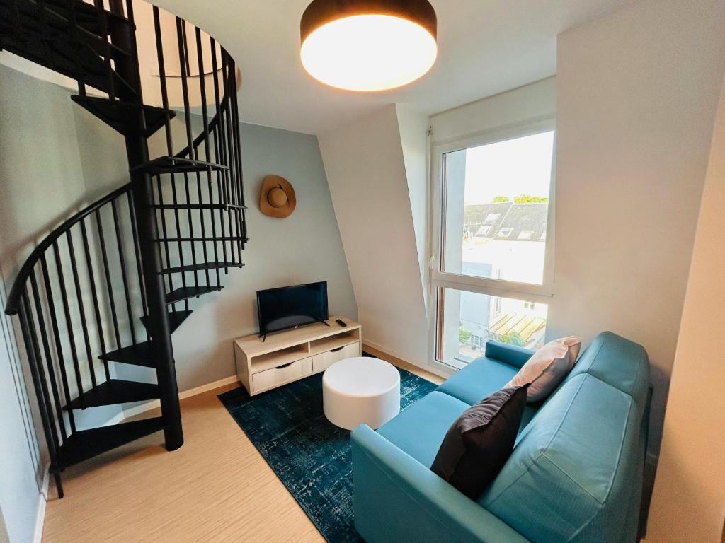 - un salon avec un canapé bleu et un escalier en colimaçon dans l'établissement We Live In R - Duplex 502, à Reims