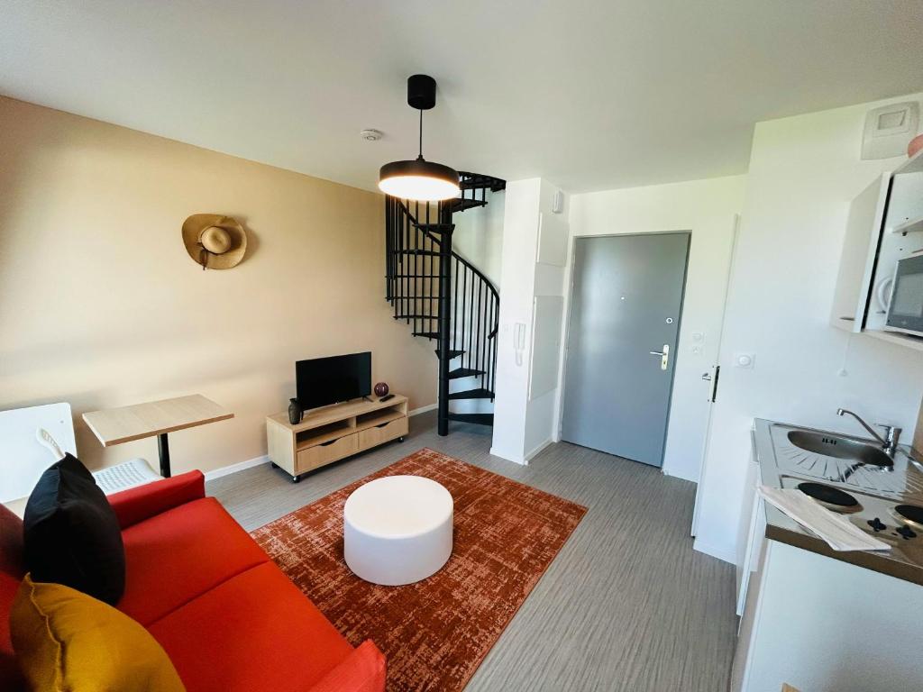 un salon avec un canapé rouge et une télévision dans l'établissement We Live In R - Duplex 501, à Reims
