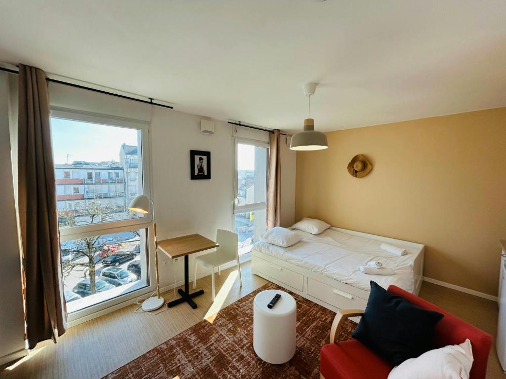 une petite pièce avec un lit et une fenêtre dans l'établissement We Live In R - Suite 404, à Reims